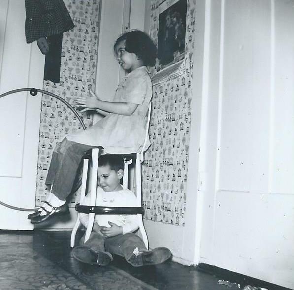 Marilyn Munsell on kitchen stool with John Munsell underneath
